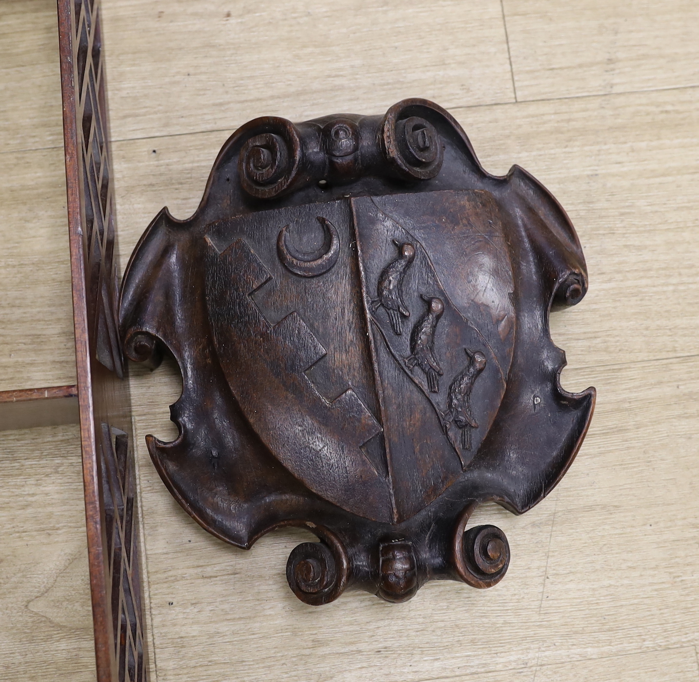A Chippendale style open hanging shelf and an 18th/19th century carved mahogany armorial shield, shelves 80cm x 40cm